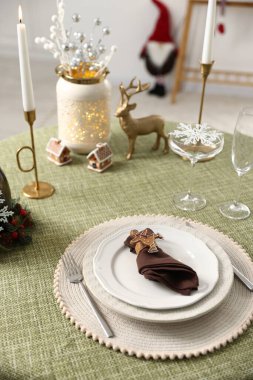 Noel dekorlu şenlik masası ve kapalı mekanda mum yakma, yakın çekim.