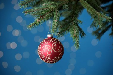Noel ağacı dalında güzel bir top, mavi arka planda, yakın plan. Bokeh etkisi