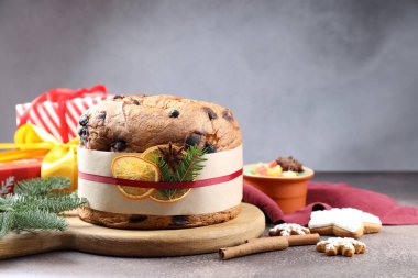Baharatlı panettone keki, şekerli meyveler ve kahverengi masa üzerindeki Noel süsü, yakın plan.