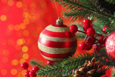 Noel ağacında kırmızı arka planda, bulanık ışıklar, yakın çekim ve yazı için yer olan güzel süsler. Bokeh etkisi