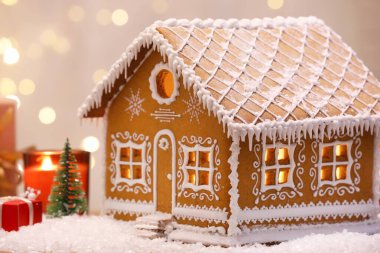 Güzel zencefilli kurabiye evi ve Noel dekoru bulanık ışıklara karşı, yakın plan