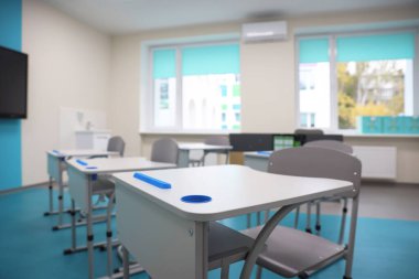Okulda masaları ve sandalyeleri olan şık bir sınıf, yakın çekim.