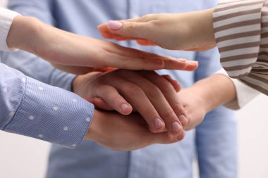 Gönüllülerden oluşan bir ekip gri arka plana el koyuyor, yakın plan.