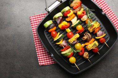 Grill pan with tasty vegetables on grey table, top view