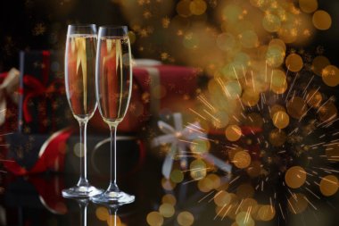 Yeni yıl kutlaması. Bir bardak köpüklü şarap, havai fişekler ve kartvizitte ışık.