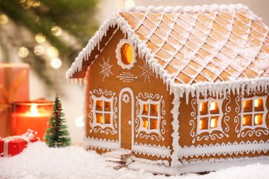 Güzel zencefilli kurabiye evi ve Noel dekoru bulanık ışıklara karşı, yakın plan