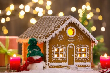 Güzel zencefilli kurabiye evi ve Noel dekoru bulanık ışıklara karşı, yakın plan