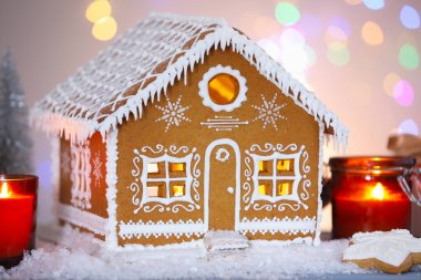 Güzel zencefilli kurabiye evi ve Noel dekoru bulanık ışıklara karşı, yakın plan