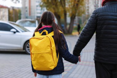 Yabancı, küçük kızı elden uzaklaştırıyor, geriye bakıyor. Çocuk tehlikede.