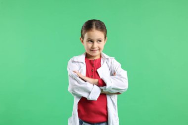 Yeşil arka planda laboratuvar önlüklü şirin küçük kız. Çocuk ve bilim