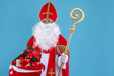 Hediye dolu bir çuval ve mavi arka planda Crozier ile Aziz Nicholas