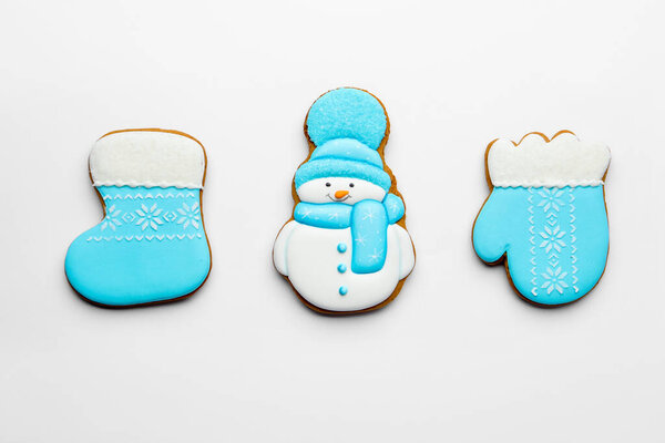 Tasty gingerbread cookies on white background, flat lay. Christmas treat