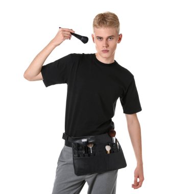 Beyaz arka planda fırça seti olan makyaj sanatçısı