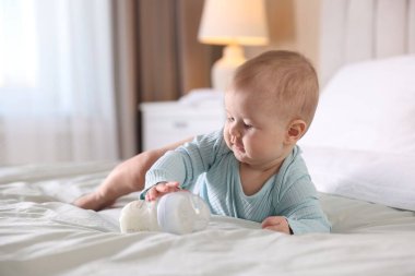 Evde yatağında biberonla beslenen tatlı bir bebek. Metin için boşluk