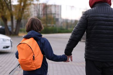 Yabancılar, küçük çocuğu dışarı çıkarıyorlar, arka manzara. Çocuk tehlikede.