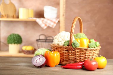 Hasır sepetin içinde farklı taze sebzeler ahşap masa içinde, metin için yer var.