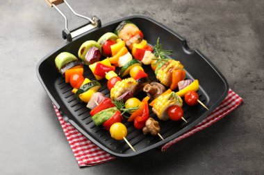 Grill pan with tasty vegetables on grey table, closeup