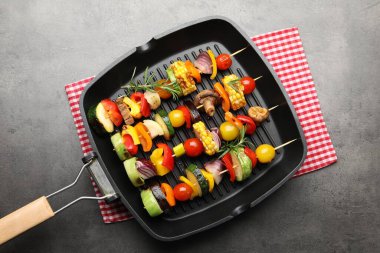 Grill pan with tasty vegetables on grey table, top view