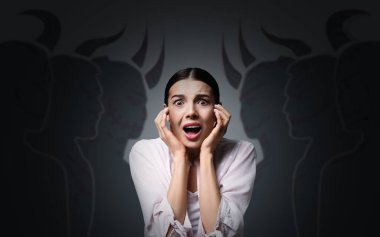 Fobi, patolojik korku. Gri arka planda korkunç şeytani varlıklarla çevrili korkmuş bir kadın.