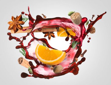 Gri arka planda şarap, baharat ve portakal dilimleri.