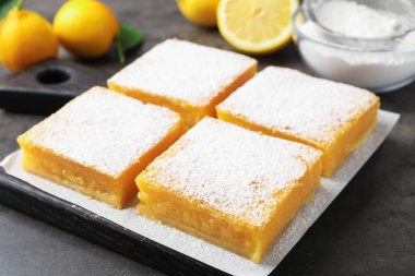 Gri masada pudra şekerli lezzetli limonlu gofretler, yakın plan.