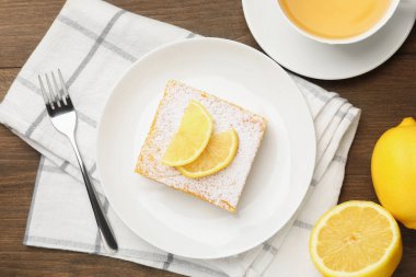 Tahta masada servis edilen pudra şekerli lezzetli limonlu pasta.