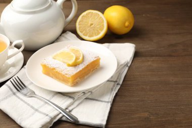 Ahşap masada servis edilen pudra şekerli limonlu tatlı, yakın plan. Metin için boşluk