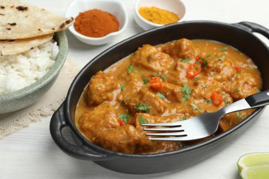 Tavuk tikka masala, pirinçli ve baharatlı beyaz ahşap masa, yakın plan.