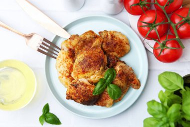 Lezzetli kavrulmuş tavuk butları ve fesleğenli beyaz fayanslı masa, düz uzanmış