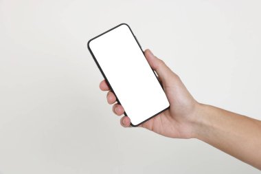 Man holding smartphone with blank screen on white background, closeup. Mockup for design