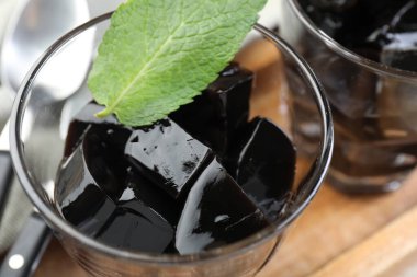 Ahşap masada servis edilen naneli tatlı bitkisel jöle, yakın plan.