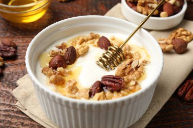 Ahşap masada sunulan bal ve fındıklı lezzetli Yunan yoğurdu, yakın plan.