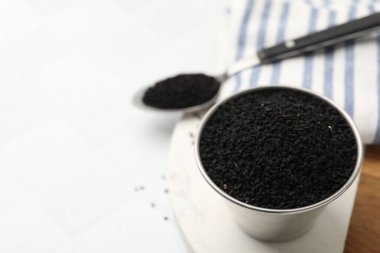 Kasede ve kaşıkta beyaz masanın üzerinde siyah bir oyma, yakın plan. Metin için boşluk