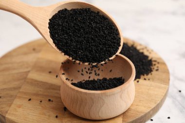 Beyaz mermer masadaki kaseye aromatik siyah oyma dökülüyor, yakın plan.