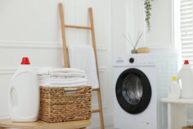 Temiz elbiseli çamaşır sepeti ve kapalı alanda deterjan.