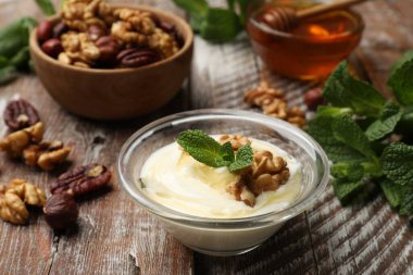 Lezzetli Yunan yoğurdu, ballı, fındıklı ve nane şekerli ahşap masa, yakın plan.