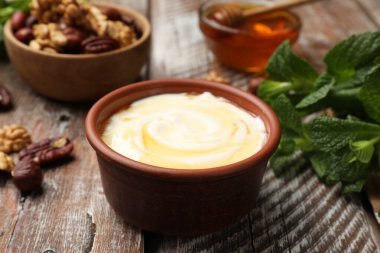 Lezzetli Yunan yoğurdu, ballı, fındıklı ve nane şekerli ahşap masa, yakın plan.