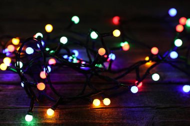 Parlak Noel ışıkları ahşap masanın üzerinde Karanlıkta, yakın plan