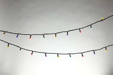 Gri arka planda parlak Noel ışıkları, yakın plan