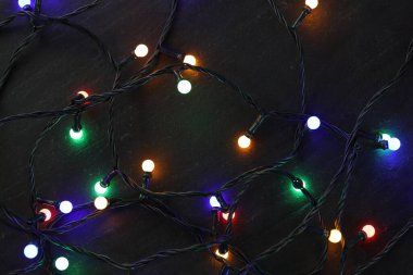 Parlak Noel ışıkları koyu dokulu masa, üst manzara