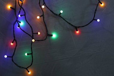 Gri desenli masada parlak Noel ışıkları, üst manzara. Metin için boşluk