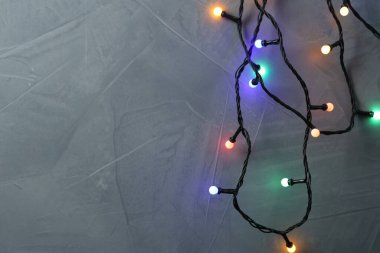 Gri desenli masada parlak Noel ışıkları, üst manzara. Metin için boşluk