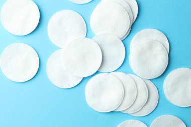 Açık mavi arkaplanda temiz pamuk pedleri, düz yatış