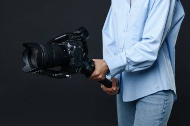 Siyah arkaplanda kamera olan titreşim sabitleyici kullanan kameraman, yakın plan