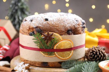 Bulanık ışıklara karşı baharatlı ve Noel dekorlu leziz panettone pastası, yakın plan. Bokeh etkisi