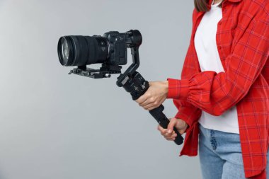 Işık arkaplanında kamera olan titreşim dengeleyici kullanan kameraman, yakın plan