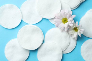 Temiz pamuk pedleri ve açık mavi arka planda papatya çiçekleri.