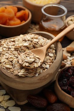 Tahıl yapıyorum. Yulaf gevreği, kurutulmuş meyve ve diğer malzemeler ahşap masada, yakın plan.