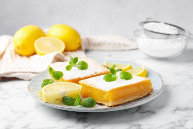 Lezzetli limonlu pudra şekeri, nane ve taze meyveli beyaz mermer masa, yakın plan.