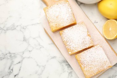 Lezzetli limonlu pudra şekeri ve beyaz mermer masada taze meyveler, düz yatak. Metin için boşluk